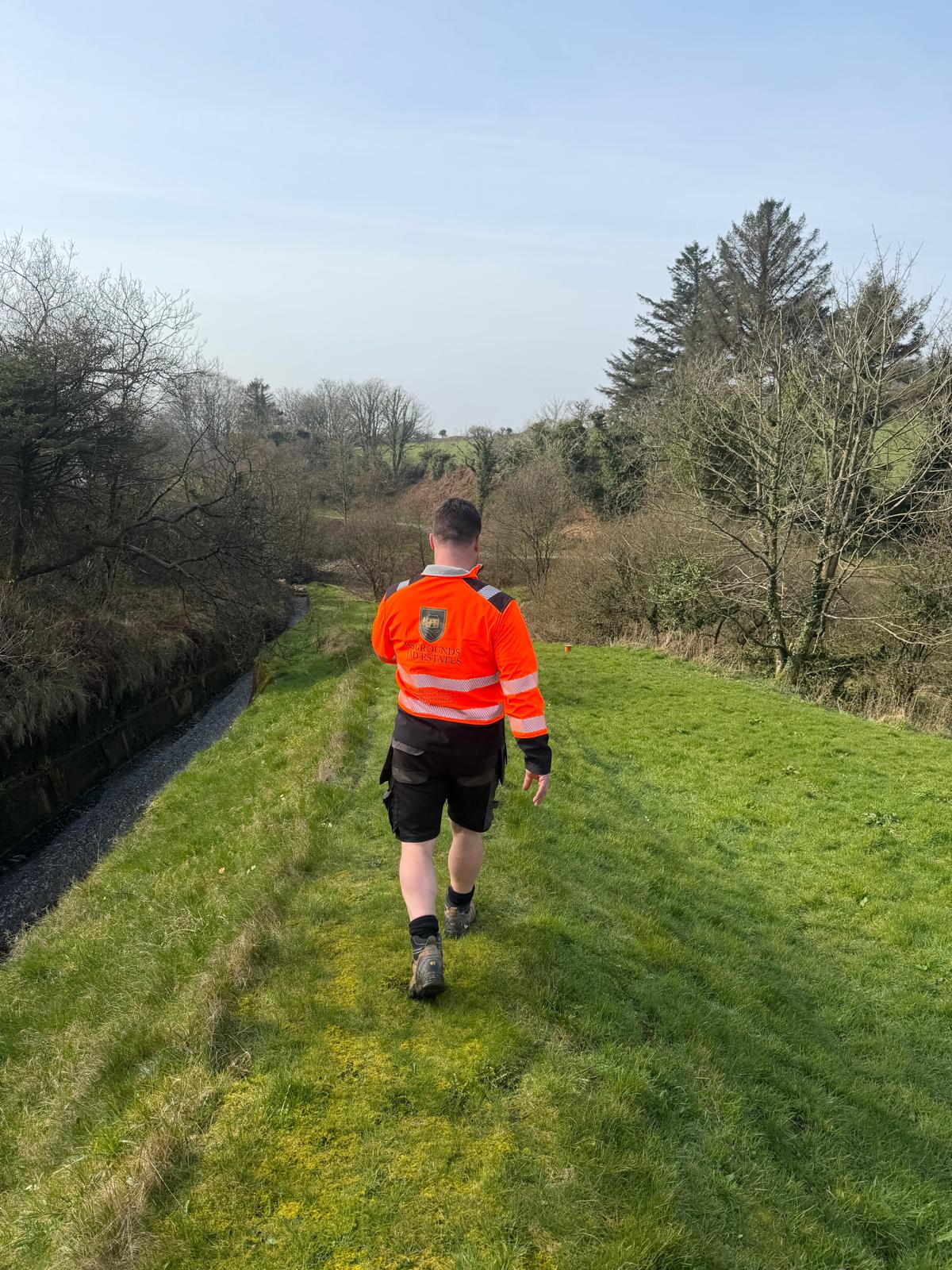 Grounds maintenance walkover across an open grassy area